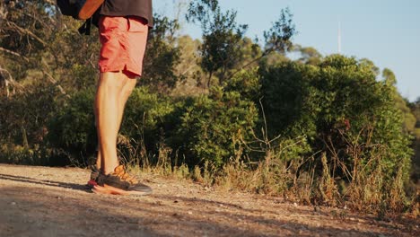 man hiking with backpack on a trail