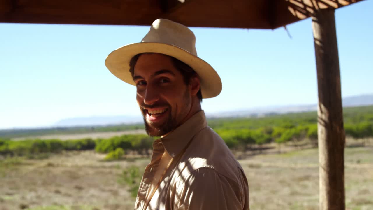 hombre sonriente de pie bajo el cobertizo 4k