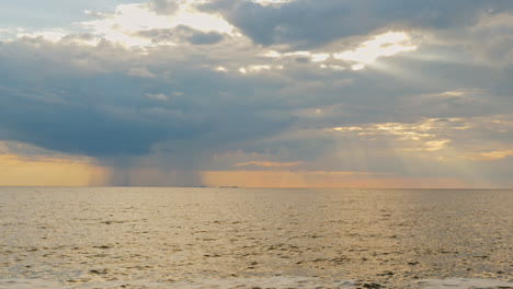 strong rain far into the sea and the setting sun with beautiful rays