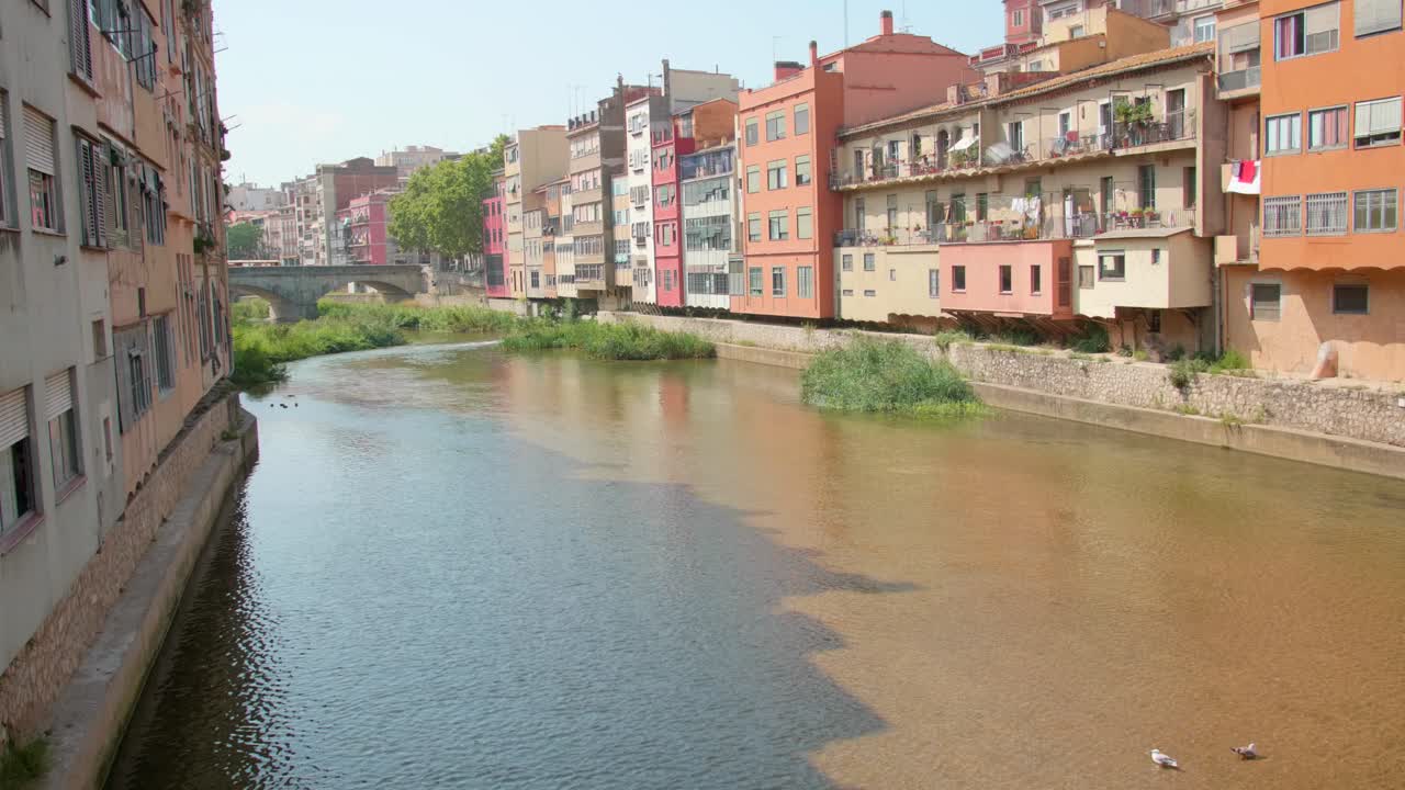 Bunte Häuser entlang des Flusses Onyar nahe einer Brücke in Girona, Katalonien, Spanien.