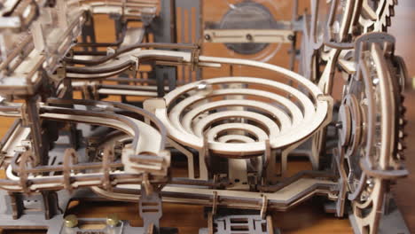 cerrar detalle de una máquina de juguete de mármol con engranajes de madera movidos con manivela