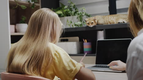 Frau-Hilft-Einem-Mädchen,-Das-Im-Klassenzimmer-Mit-Einem-Laptop-Arbeitet