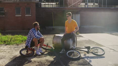 BMX-riders-sitting-in-a-yard-talking