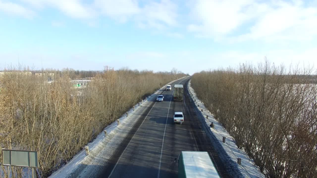 Snowy winter highway. Aerial view of cars on winter highway around trees