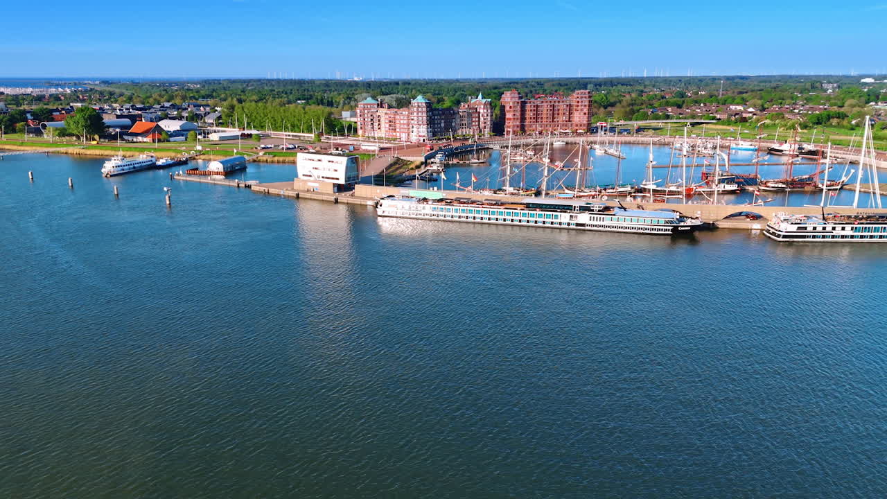 Cruise ships at Dutch marina. Cruise ships are docked at a busy marina in the Netherlands on a bright sunny day, with green landscapes nearby