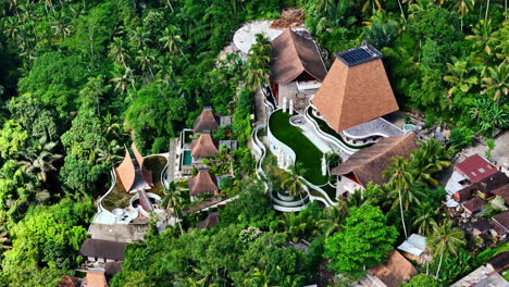 lush jungle surrounds luxury resort villas in tropical ubud, bali from above