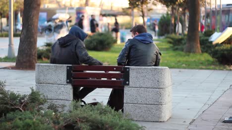 una joven pareja sentada en un banco en el parque