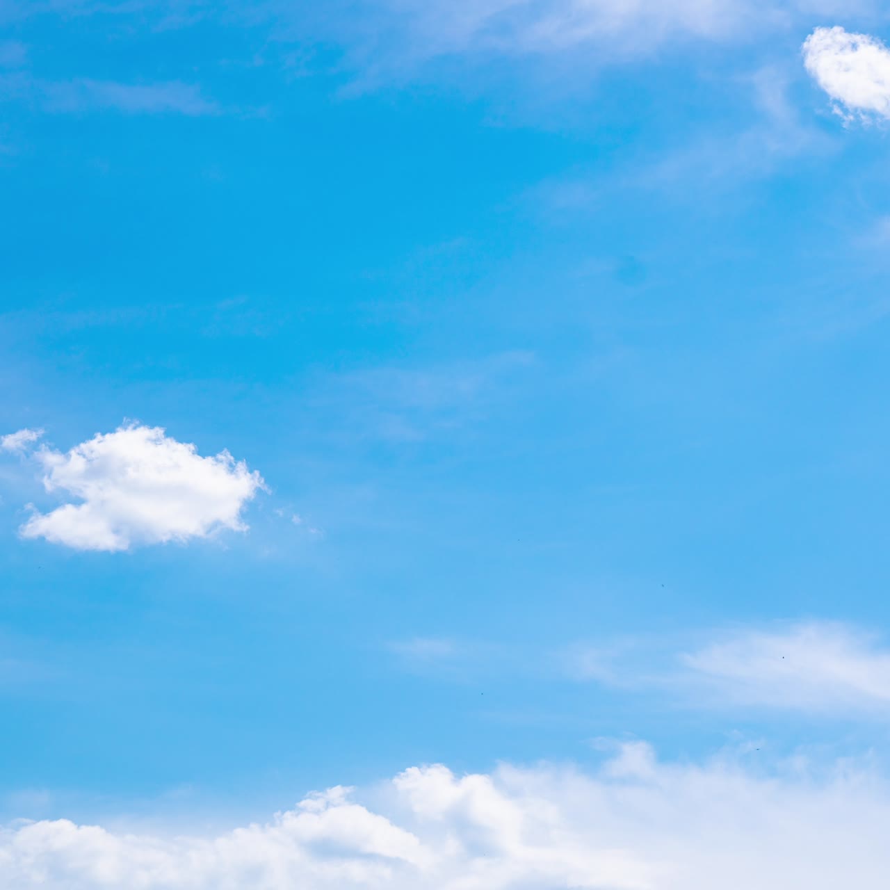 Stunning turquoise horizon with fluffy white clouds lit with bright sun. Soft cumulus clouds movement. Low angle view timelapse