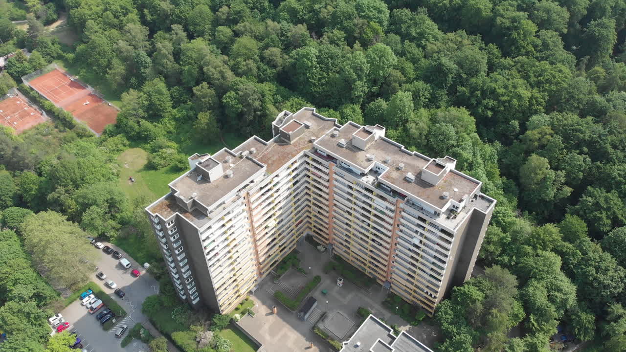 apartment Building with massive extended green forest behind, Emmertsgrund, Heidelberg, Germany, crane aerial shot