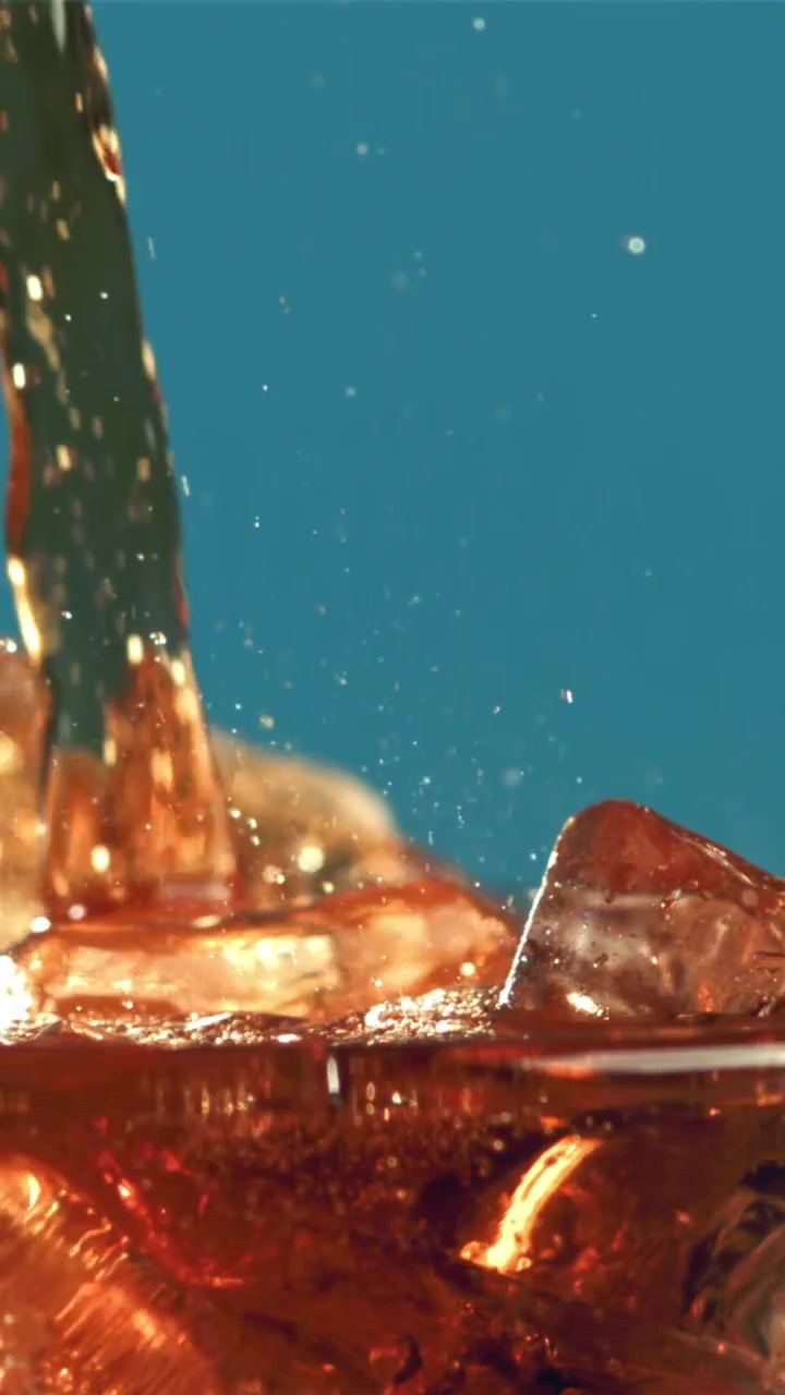 Bevanda rinfrescante alla cola versata sul ghiaccio al rallentatore