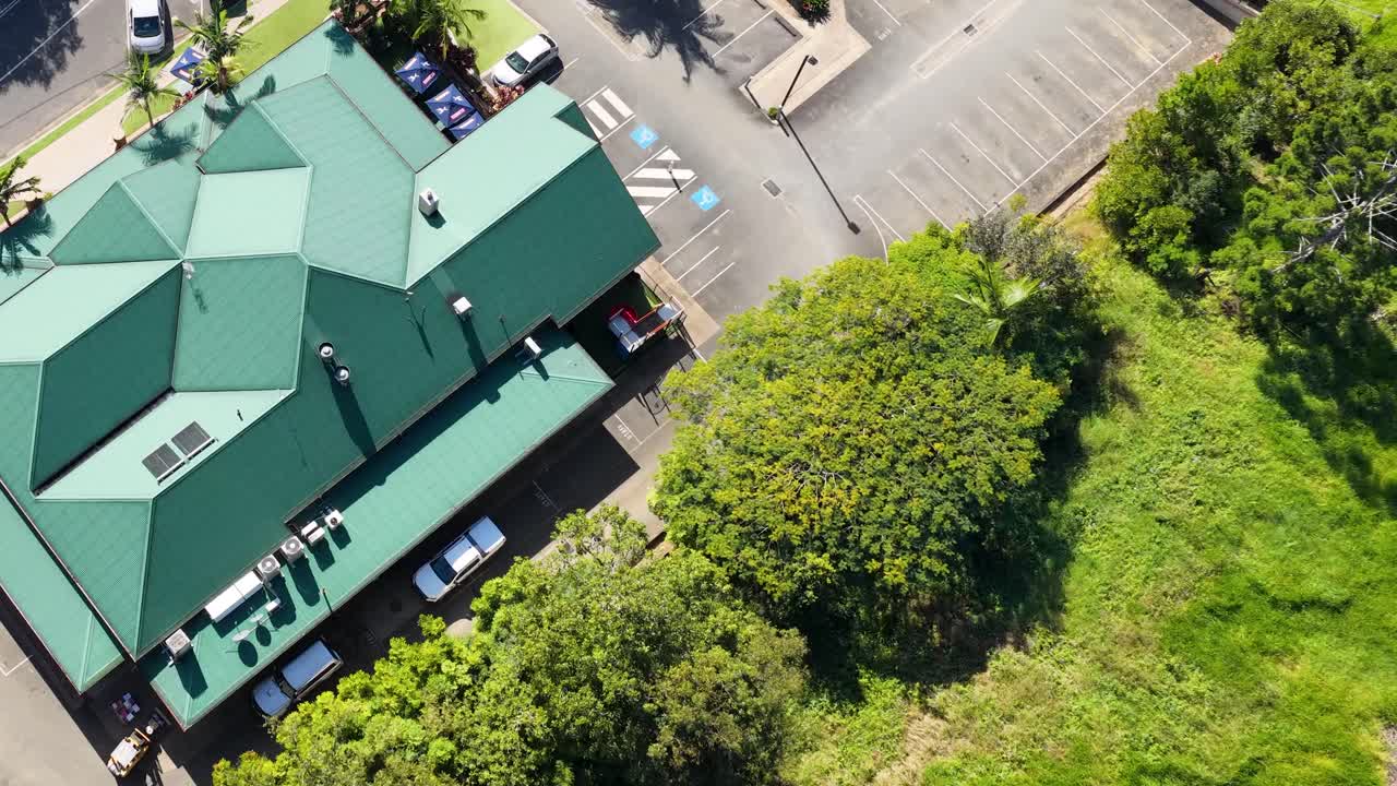 Drone footage captures a building with a green roof surrounded by lush vegetation in Uki, NSW, Australia