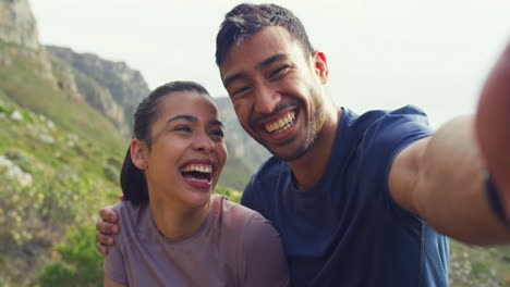 Portrait-of-couple-laughing-taking-selfie