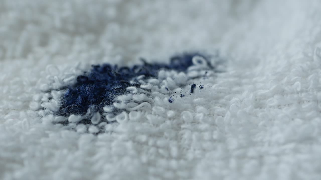 mancha azul en una toalla de tela de terry blanca