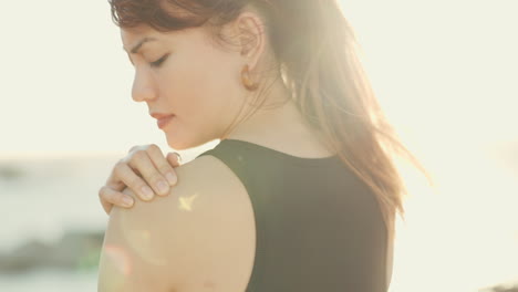 hand, shoulder pain and beach with a runner woman