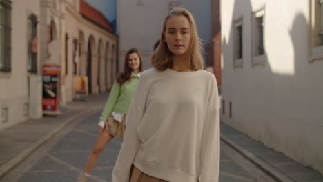 two young women posing in an urban street scene