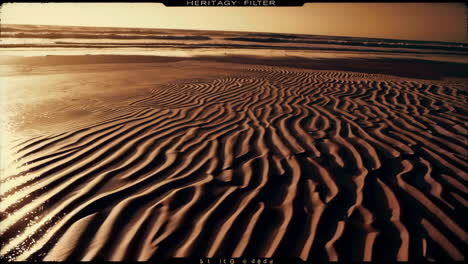 ocean waves and sand ripples at sunset with heritage filter
