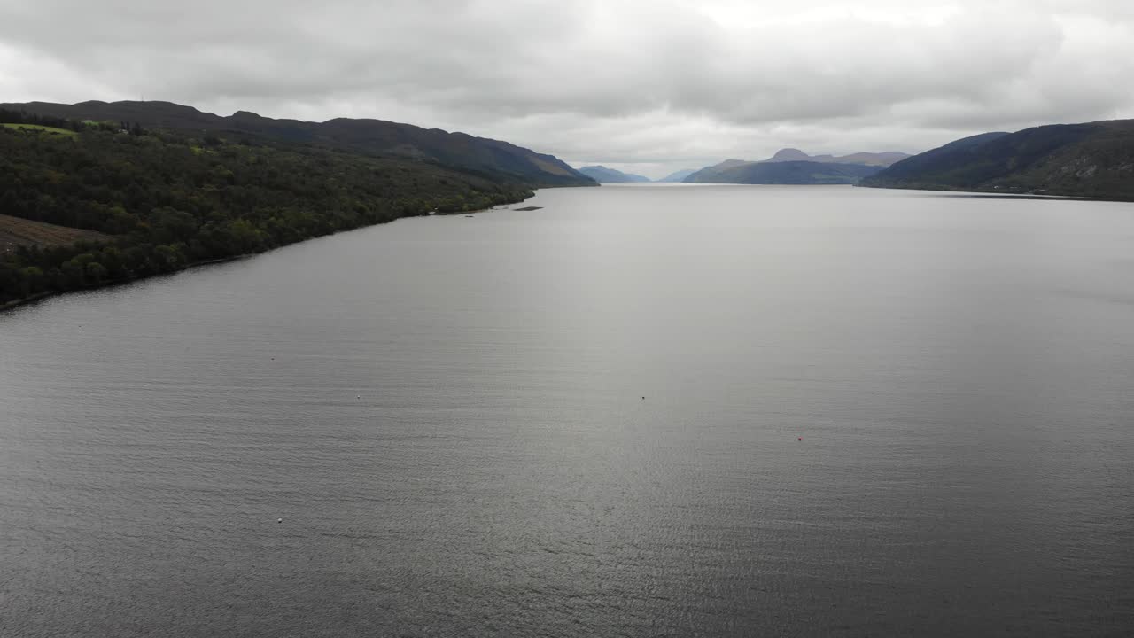 vuelo aéreo sobre las aguas del lago ness con nubes por encima
