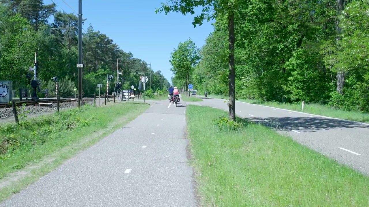 Ciclisti che pedalano lungo una strada panoramica di campagna.