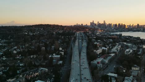 Toma-Aérea-De-Timelapse-Del-Puente-Del-Canal-De-Navegación-Con-El-Horizonte-De-Seattle-Durante-La-Puesta-De-Sol