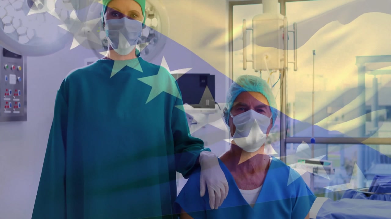 Surgeon and assistant donning masks and caps in OR before powering surgical light starting surgery
