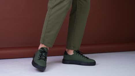 man wearing olive green sneakers and khaki trousers