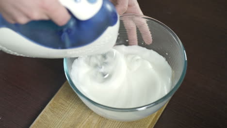 beating egg proteins in the glass bowl. process of whipping proteins eith mixer