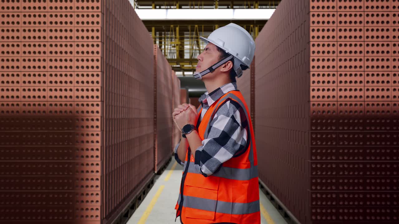Construction worker praying in a brick factory