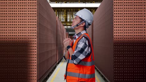 construction worker praying in a brick factory