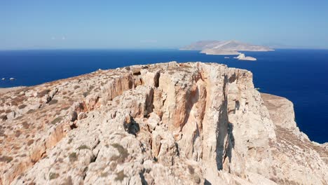 aerial flying over mountain cliffs reveal mediterranean deep blue sea scenery, greece