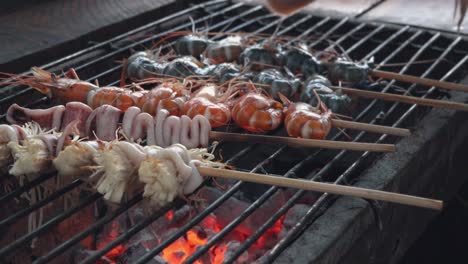 squid added to a grill with seafood skewers