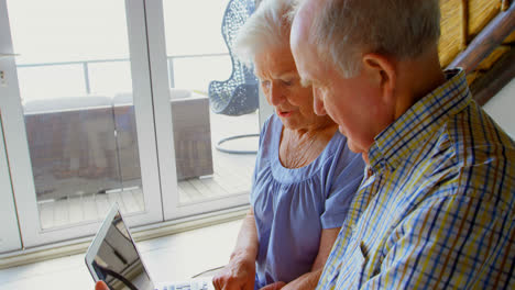 side view of caucasian senior couple using laptop at comfortable home 4k