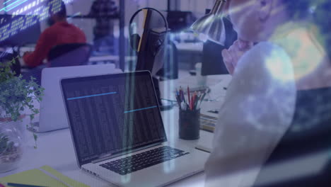 Person working at desk with laptop, data processing animation overlay