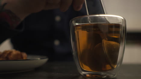 person using a infuser to brew the evening cup of tea - close up