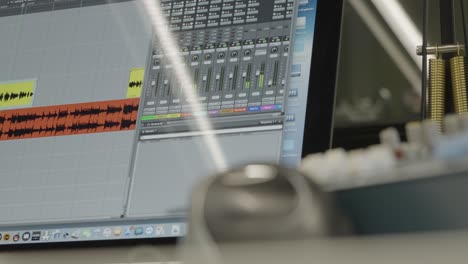 software de producción de audio en una pantalla de computadora, niveles de audio del ecualizador de sonido moviéndose hacia arriba y hacia abajo