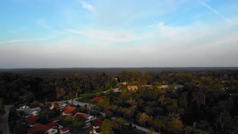 Amazing-cinematic-4K-sunset-residential-drone-footage-after-deforestation-issue-consists-of-homes,-road,-trees,-lake-and-infrastructure-in-the-middle-of-tropical-forest-located-in-Riau,-Indonesia