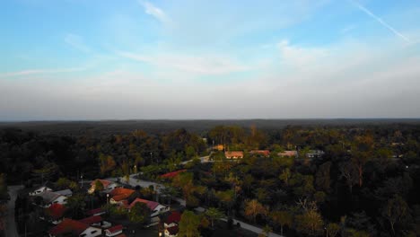 amazing cinematic 4k sunset residential drone footage after deforestation issue consists of homes, road, trees, lake and infrastructure in the middle of tropical forest located in riau, indonesia