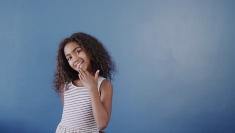 Happy-african-american-girl-using-sign-language-on-blue-background-with-copy-space,-slow-motion