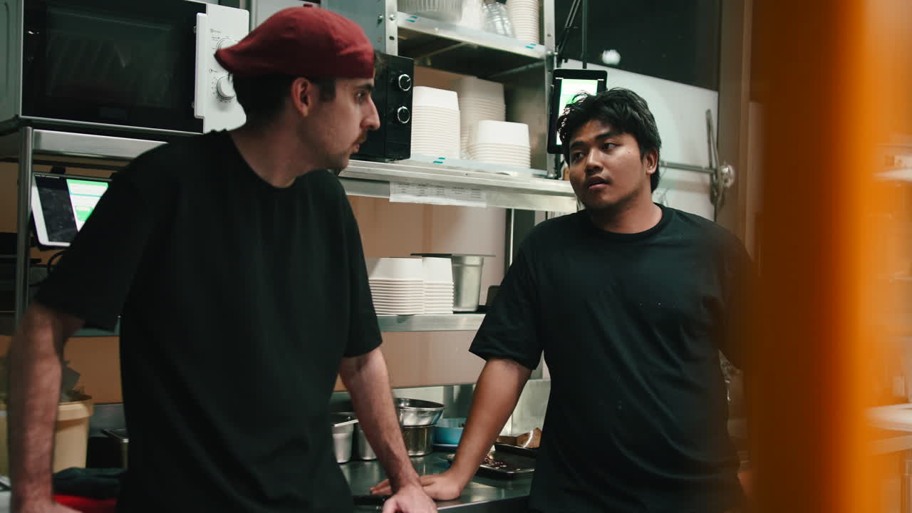Two Chefs Talking in a Restaurant Kitchen