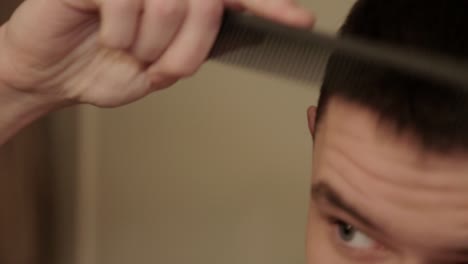 close up of a young person combing their short hair