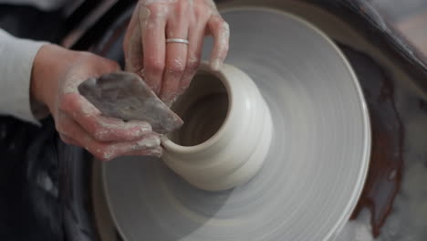 close-up view of hands shaping clay on a pottery wheel