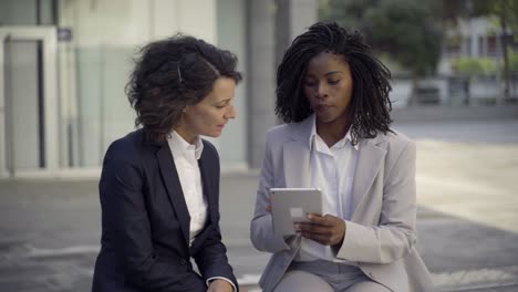 smiling female colleagues with tablet pc