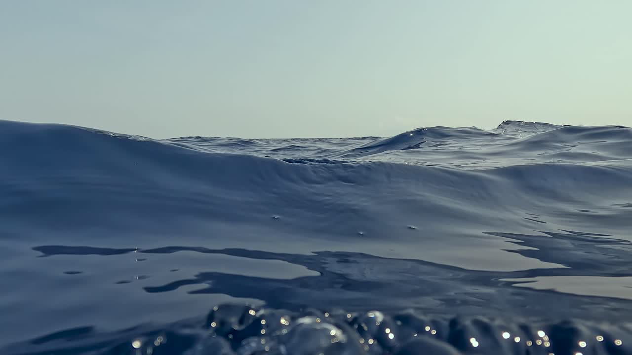 Slow motion of smooth swell waves on surface of deep blue ocean water of Timor-Leste in Southeast Asia