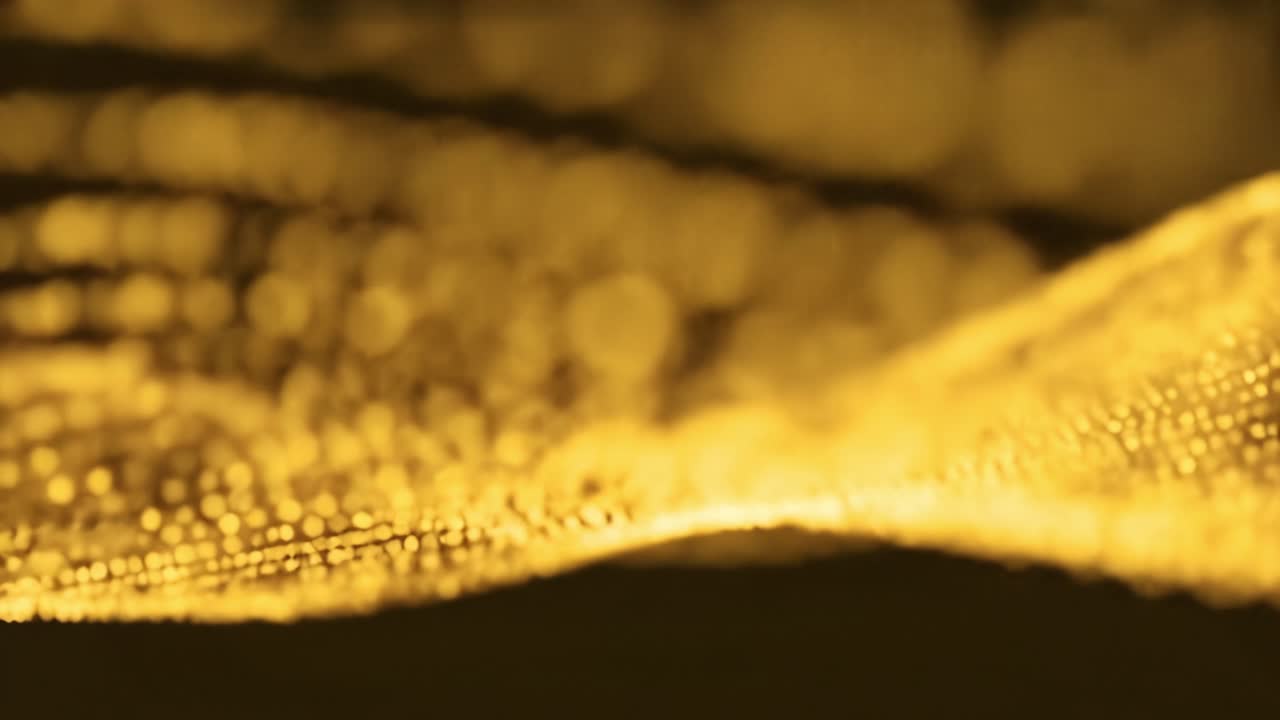 Intricate golden wave patterns shimmer and flow elegantly against a dark backdrop, creating a mesmerizing visual experience that captures attention and sparks imagination.