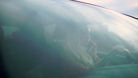woman driving a car while talking on a phone
