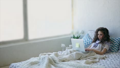 woman working on laptop in bed