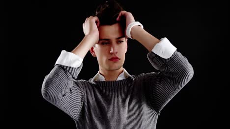 androgynous man posing against black background