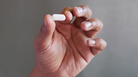 person holding a white pill