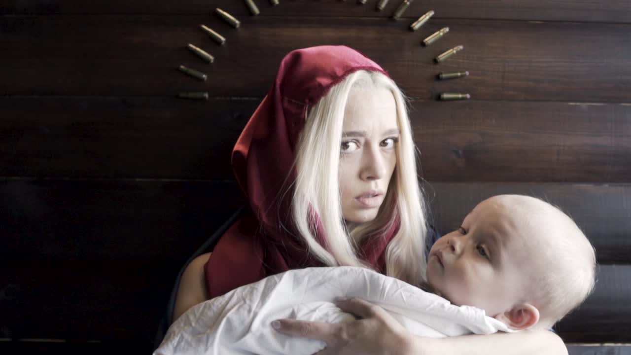 mujer sosteniendo al bebé con una expresión dramática