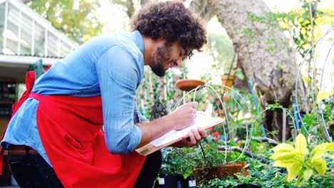 jardinero tomando notas de las plantas