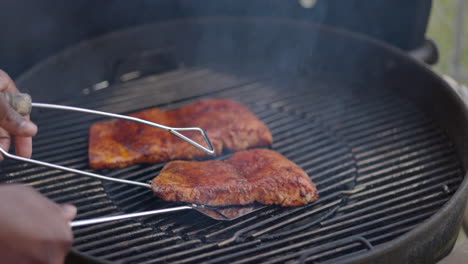 asar salmón frotado con especias en la barbacoa del patio trasero - cámara lenta volteando un filete